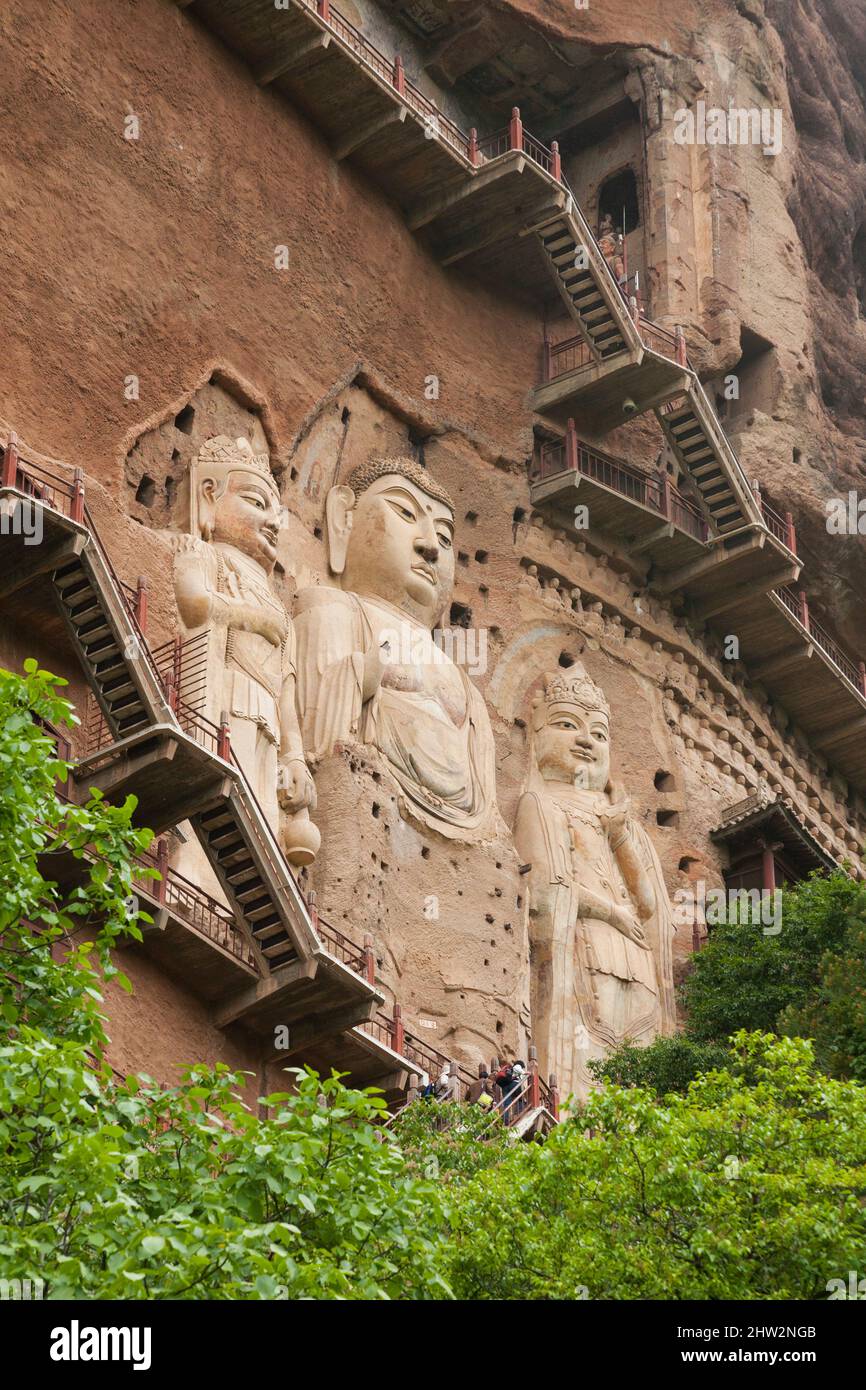Représentations de Bouddha figures les représentations et les images bouddhistes (qui semblent être récemment restaurées à l'aide de béton) sur la face rocheuse des Grottes de Maijishan, autrefois romanisées comme Maichishan, sont une série de 194 grottes coupées sur le flanc de la colline de Majishan à Tianshui, province de Gansu, Chine. Des escaliers et des passerelles sont fixés à la face de roche pure pour permettre aux visiteurs d'entrer en contact étroit avec les figures et les anciennes sculptures en pierre du site. (67 /125) Banque D'Images