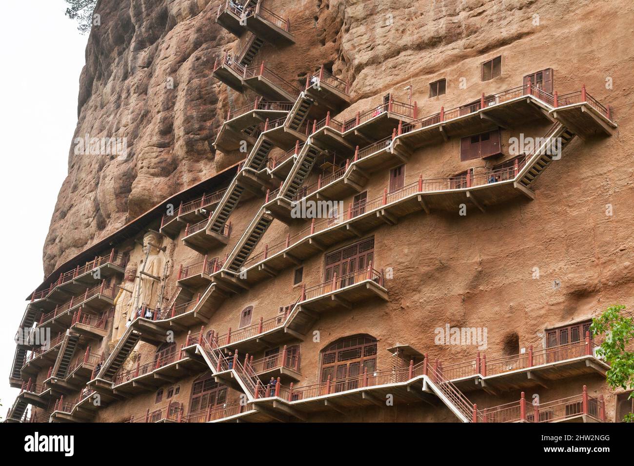 Les marches et les passerelles attachées à la roche permettent aux visiteurs de voir les anciennes statues en argile de Bouddha et de la statue de divinités bouddhistes attachées et sculptées dans la surface de pierre de la face de roche.les grottes de Maijishan, autrefois romanisées comme Maichishan, Sont une série de 194 grottes coupées sur le flanc de la colline de Majishan à Tianshui, province de Gansu, Chine. (67/125) Banque D'Images