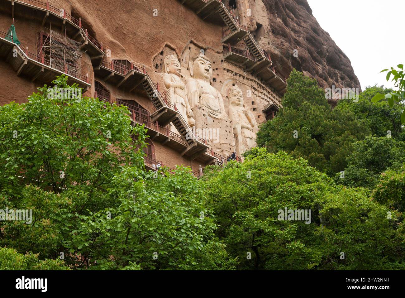 Les marches et les passerelles attachées à la roche permettent aux visiteurs de voir les anciennes statues sculptées du jour bouddhiste qu'elle est attachée et sculptée dans la surface de pierre de la face rocheuse.les grottes de Maijishan, autrefois romanisées comme Maichishan, Sont une série de 194 grottes coupées sur le flanc de la colline de Majishan à Tianshui, province de Gansu, Chine. (67/125) Banque D'Images