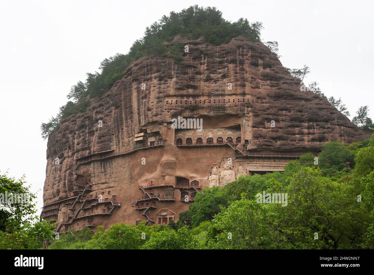 Les marches et les passerelles attachées à la roche permettent aux visiteurs de voir les anciennes statues en argile de Bouddha et de la statue de divinités bouddhistes attachées et sculptées dans la surface de pierre de la face de roche.les grottes de Maijishan, autrefois romanisées comme Maichishan, Sont une série de 194 grottes coupées sur le flanc de la colline de Majishan à Tianshui, province de Gansu, Chine. (67/125) Banque D'Images