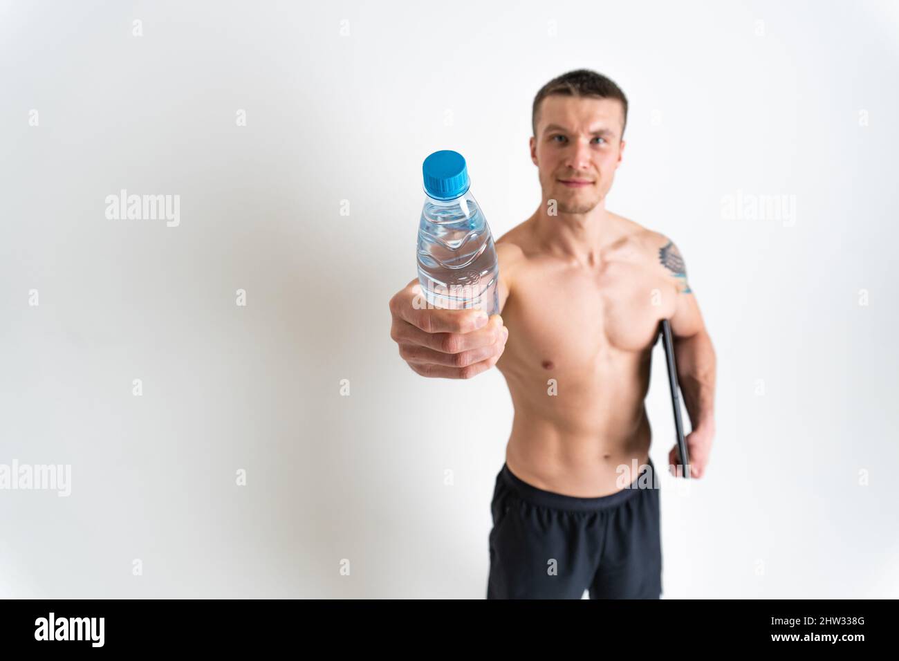 L'homme de boire-eau fitness est pompé avec une serviette sur un fond blanc isolé fitness athlète entraînement gym gym bouteille gars, muscles cardio Banque D'Images