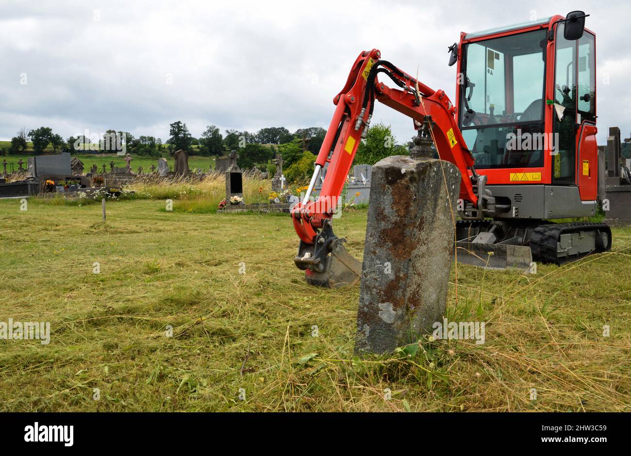 Une pelle hydraulique pour creuser une tombe dans un cimetière pour l'enterrement ou l'exhumation. Banque D'Images