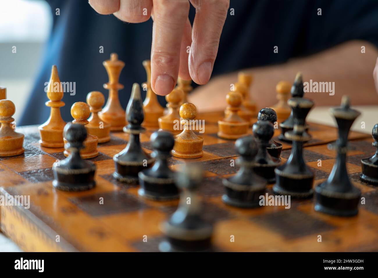 joueur jouant son prochain pas de mouvement sur la vieille carte d'échecs vintage . Banque D'Images