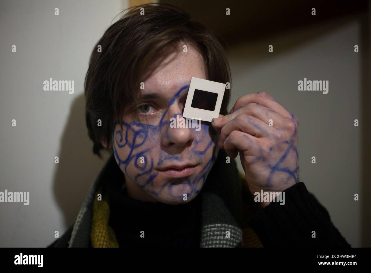 Un gars avec des dessins sur son visage. Roi de la fête. Le chercheur spirituel est fou. Un jeune homme avec une photo sur son visage. Homme d'affaires de Pottert. Un sous Banque D'Images