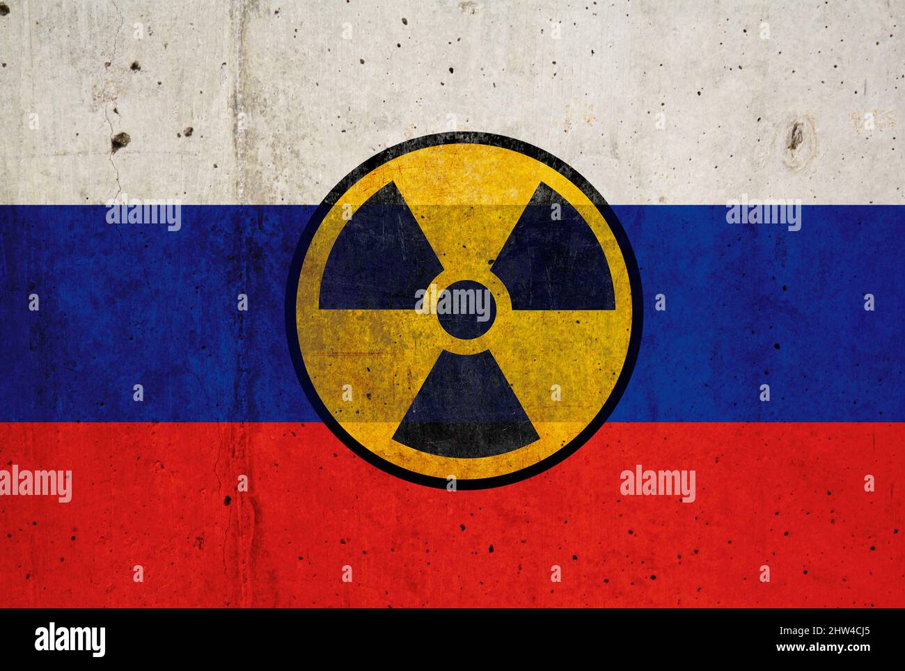 Drapeau russe sur le mur et symbole radioactif. Concept des armes nucléaires Banque D'Images