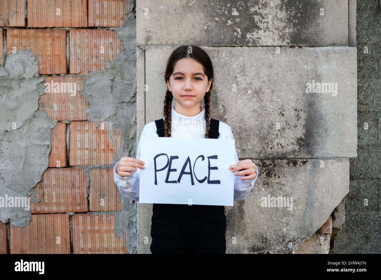 Enfant fille tenant une affiche avec la PAIX écrite en appui à la paix. Concept de "pas de guerre" en Ukraine et dans le monde. Conflit russe en faveur de pe Banque D'Images