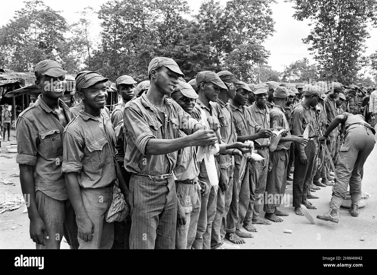 Un grand groupe de soldats de Biafran vu ici pendant le conlifct, certains prenant une pause pour un peu de nourriture. 11th juin 1968 la guerre civile nigériane, également connue sous le nom de guerre du Biafran, a duré deux ans et demi, du 6 juillet 1967 au 15 janvier 1970, et a été combattue pour contrer la sécession du Biafra du Nigeria. Le peuple indigène Igbo de Biafra a estimé qu'il ne pouvait plus coexister avec le gouvernement fédéral dominé par le Nord après l'indépendance de la Grande-Bretagne. Les tensions politiques, économiques, ethniques, culturelles et religieuses se sont finalement refaites dans la guerre civile après le coup d'État militaire de 1966 Banque D'Images