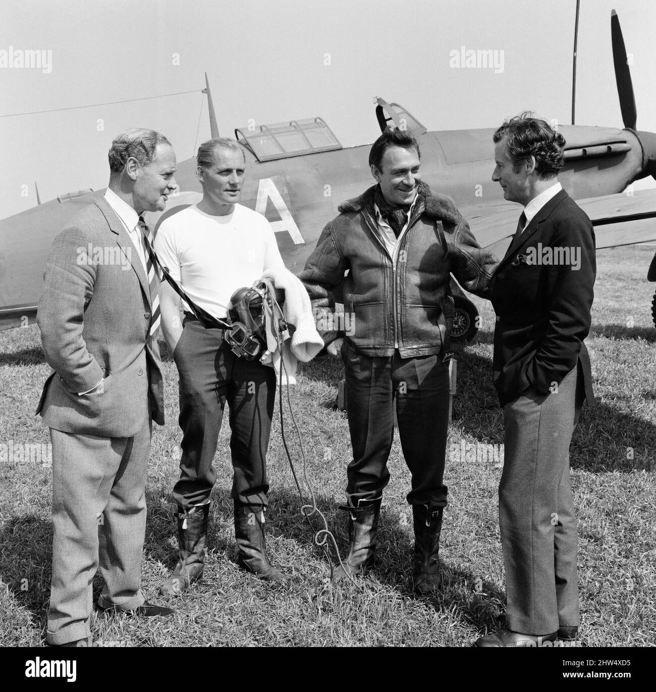 Des pilotes célèbres de la bataille d'Angleterre ont visité la station de la RAF à Duxford, près de Cambridge, aujourd'hui où le film de la bataille d'Angleterre est réalisé. La station est censée être une station RAF en France, juste avant Dunkerque. Douglas Bader (à gauche) parle aux stars du film Robert Shaw et Christopher Plummer pendant que Peter Townsend écoute. Un Spitfire est en arrière-plan. 28th mai 1968. Banque D'Images