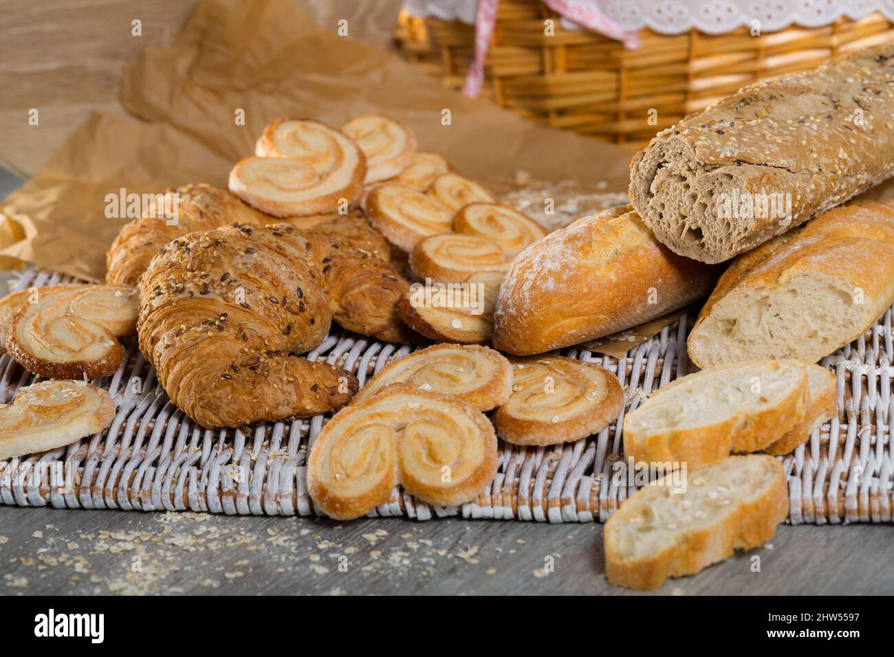 Baguettes de blé et de grain, croissants et biscuits sur tapis en osier Banque D'Images