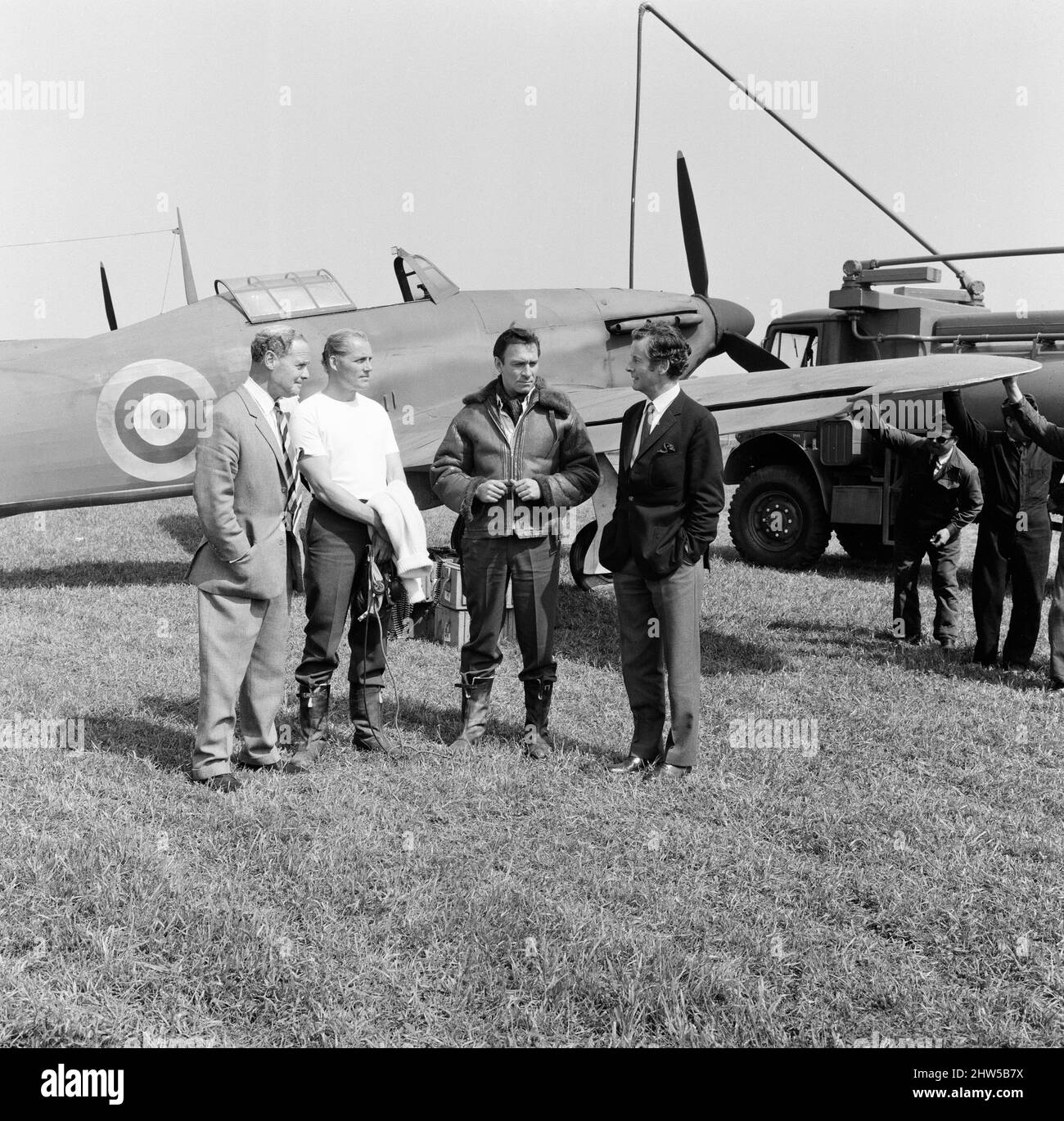Des pilotes célèbres de la bataille d'Angleterre ont visité la station de la RAF à Duxford, près de Cambridge, aujourd'hui où le film de la bataille d'Angleterre est réalisé. La station est censée être une station RAF en France, juste avant Dunkerque. Douglas Bader (à gauche) parle aux stars du film Robert Shaw et Christopher Plummer pendant que Peter Townsend écoute. Un Spitfire est en arrière-plan. 28th mai 1968. Banque D'Images