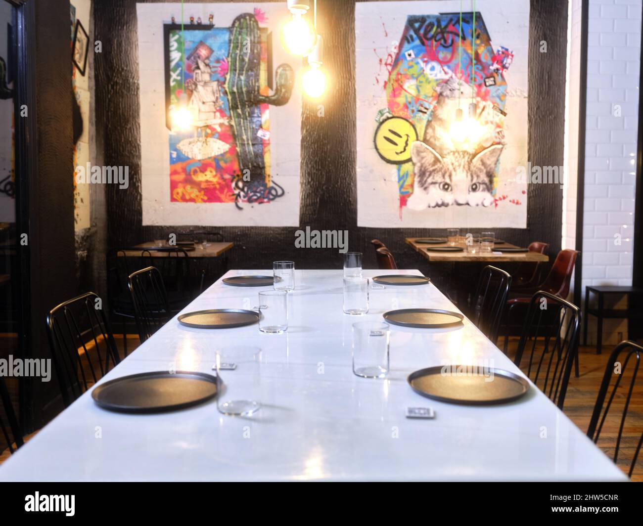 Table de restaurant avec peintures contemporaines en arrière-plan Banque D'Images