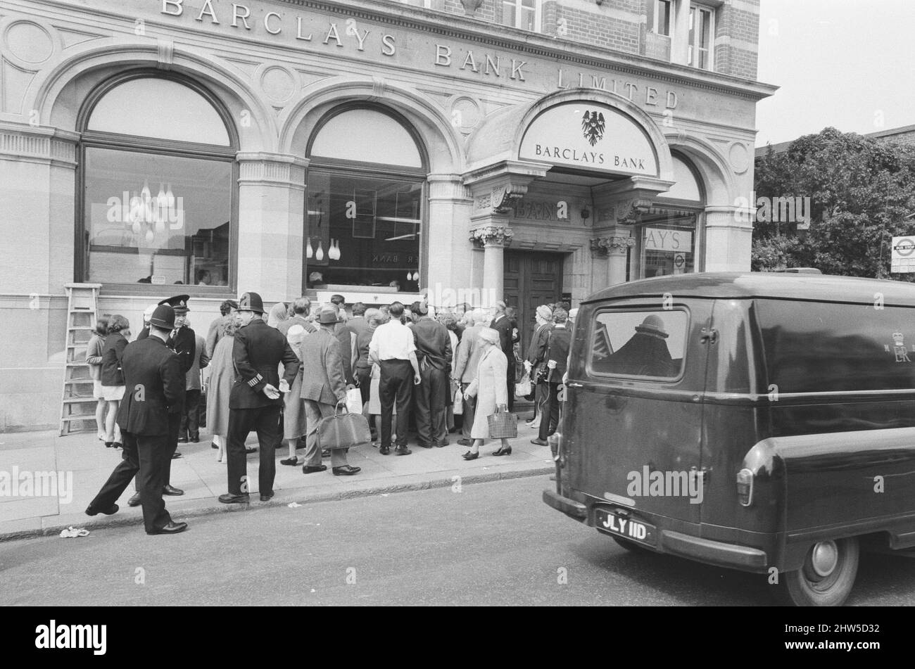 Le premier guichet automatique de Worlds, Cash machine, est dévoilé à la Barclays Bank, à Enfield, Middlesex, juste au nord de Londres. 27th juin 1967. La photo montre la foule de clients et de spectateurs locaux, voyant le premier guichet automatique au monde travailler pour la première fois. Barclays ATM, 27th juin 1967. Sir Thomas Bland, vice-président de Barclays Bank, dévoile un robot de caisse qui distribue de l'argent à tout moment du jour ou de la nuit. Conçue et développée conjointement avec de la rue instruments et le service des services de gestion des banques, la machine BarclayCash est installée dans la succursale d'Enfield. L'acteur Reg Varney a pris le temps de quitter Filmi Banque D'Images