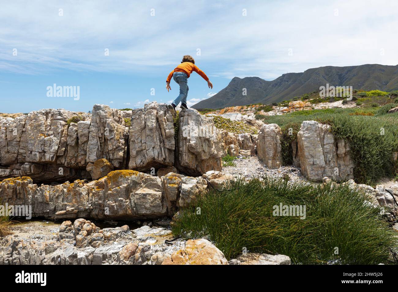 Afrique du Sud, Hermanus, Boy (8-9) exploration de rochers sur la plage de Sandbaai Banque D'Images