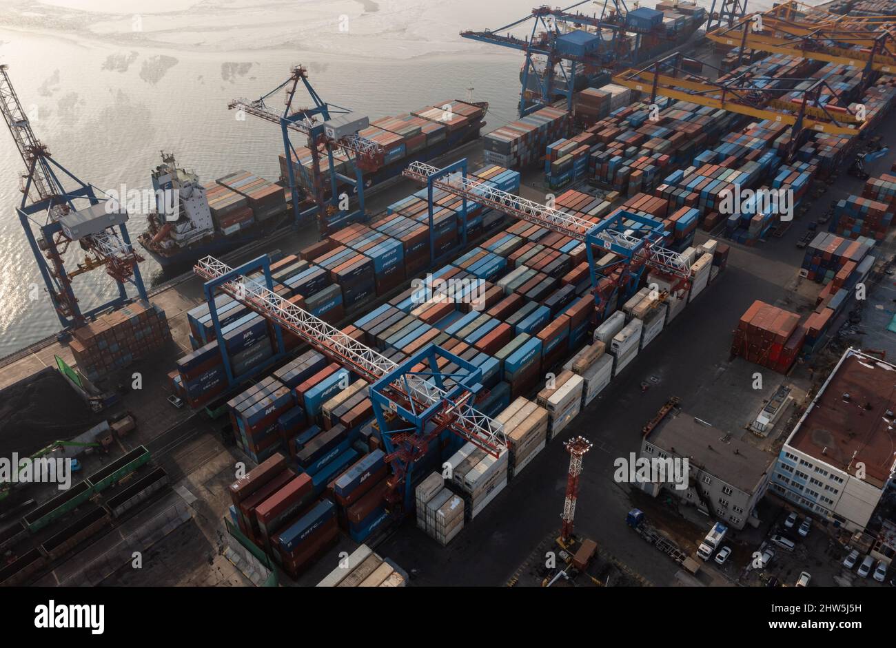 Vladivostok, Russie - 26 janvier 2022 : Vue de dessus du terminal des conteneurs du port maritime.En hiver, un bateau à conteneurs est en train de charger à l'embarcadère. Banque D'Images