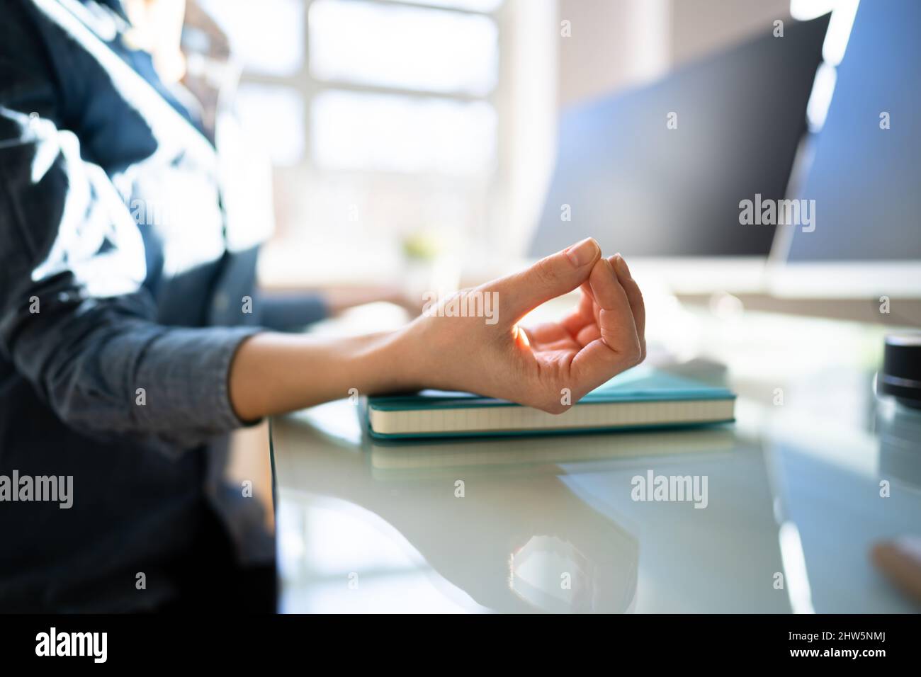 Gestion du stress chez la femme. Méditer près de l'ordinateur de bureau Banque D'Images