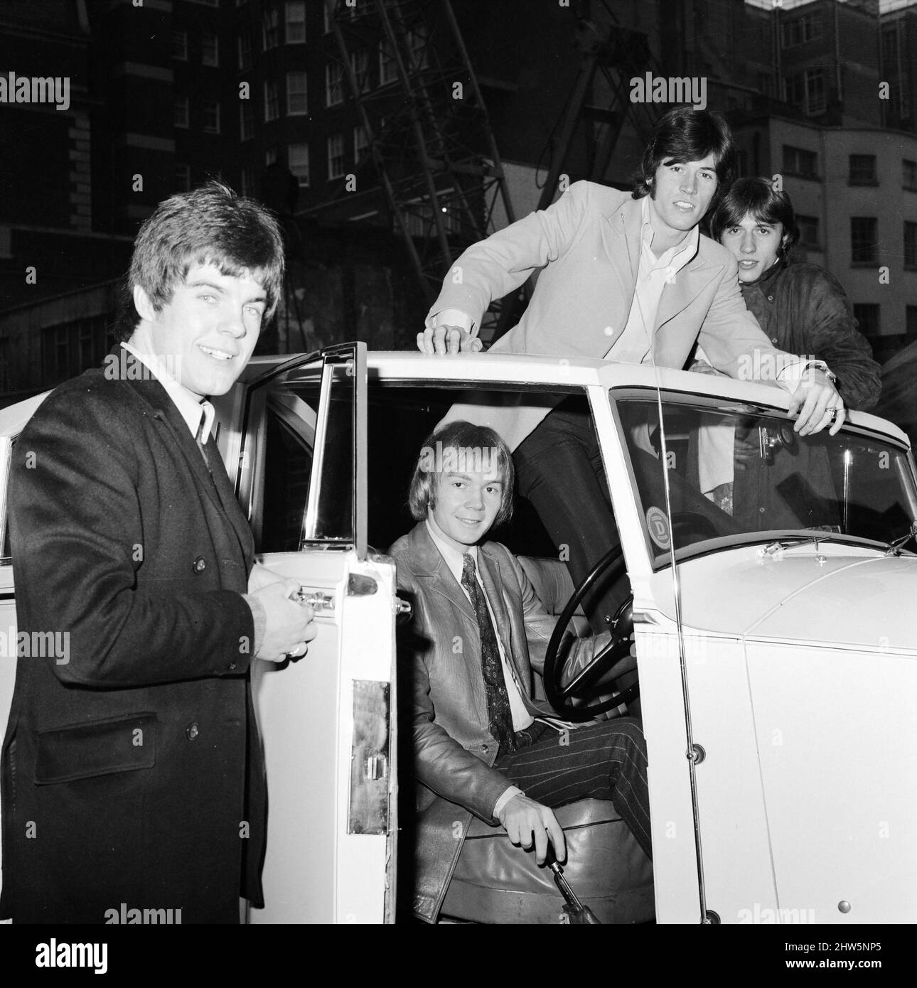 Les Bee Gees examinent un cadeau de Noël de l'agent Robert Stigwood, un 1948 Rolls Royce Silver Wraith, 12th décembre 1967. La voiture a été offerte comme cadeau spécial pour marquer et célébrer les 1 millions de ventes record de leur seul Massachusetts. Quatre des cinq membres du groupe regardent la voiture et lui donnent un vernis et propre. M. Stigwood a eu la voiture entièrement retapissée et peinte, et le moteur a été remis en état. Photo : Colin Peterson, Vince Melouney, Barry Gibb et Robin Gibb dans Adams Row, Mayfair (Robin Gibb n'était pas disponible pour la photo) Banque D'Images