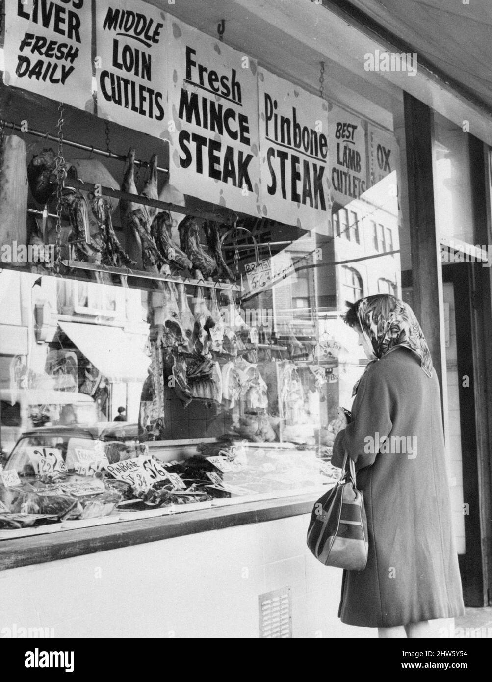 Femme regardant à travers la fenêtre de la boutique de bouchers, Cardiff, pays de Galles, 2nd octobre 1967. Banque D'Images