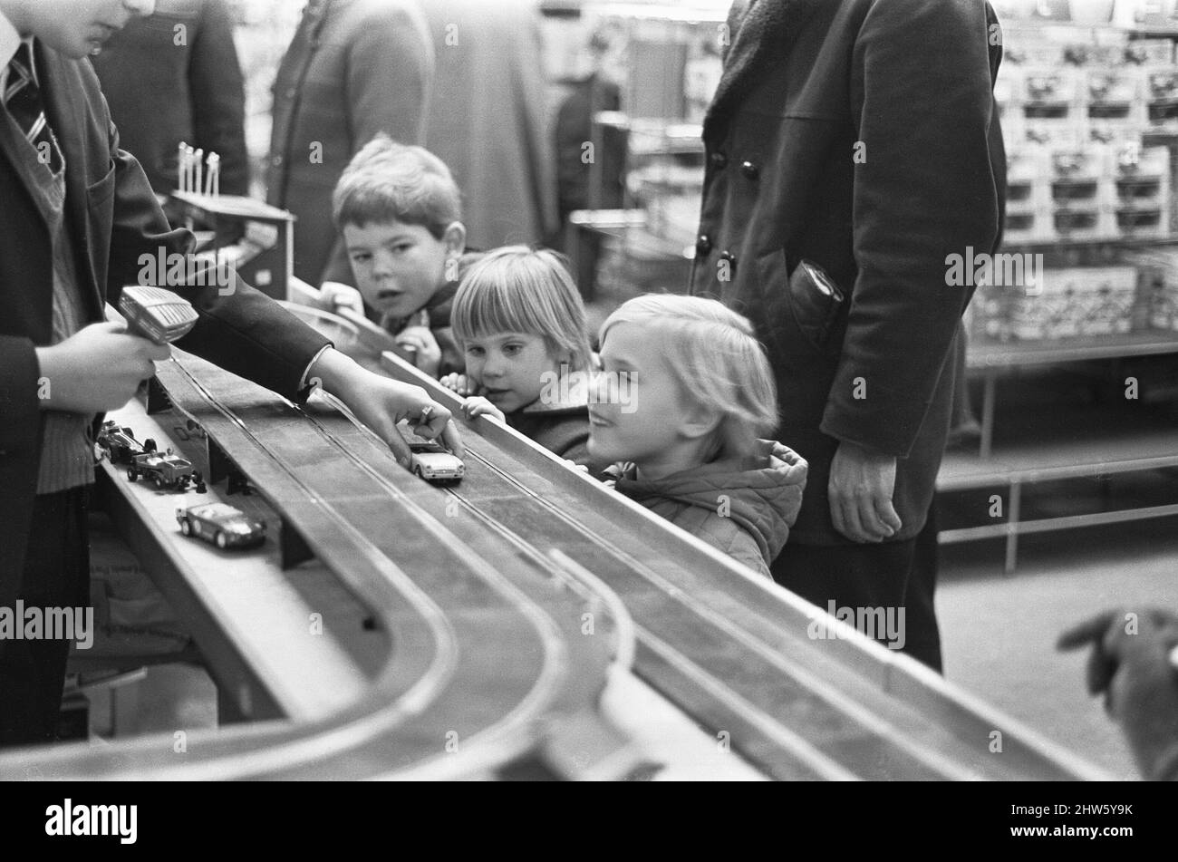 Un groupe d'enfants regardent de façon prolongée la dernière course de voiture à sous Scalextric dans le département de jouets de Heelas grand magasin à Reading, tous espèrent que le Père Noël a un dans son sac pour eux. 24th décembre 1968 Banque D'Images