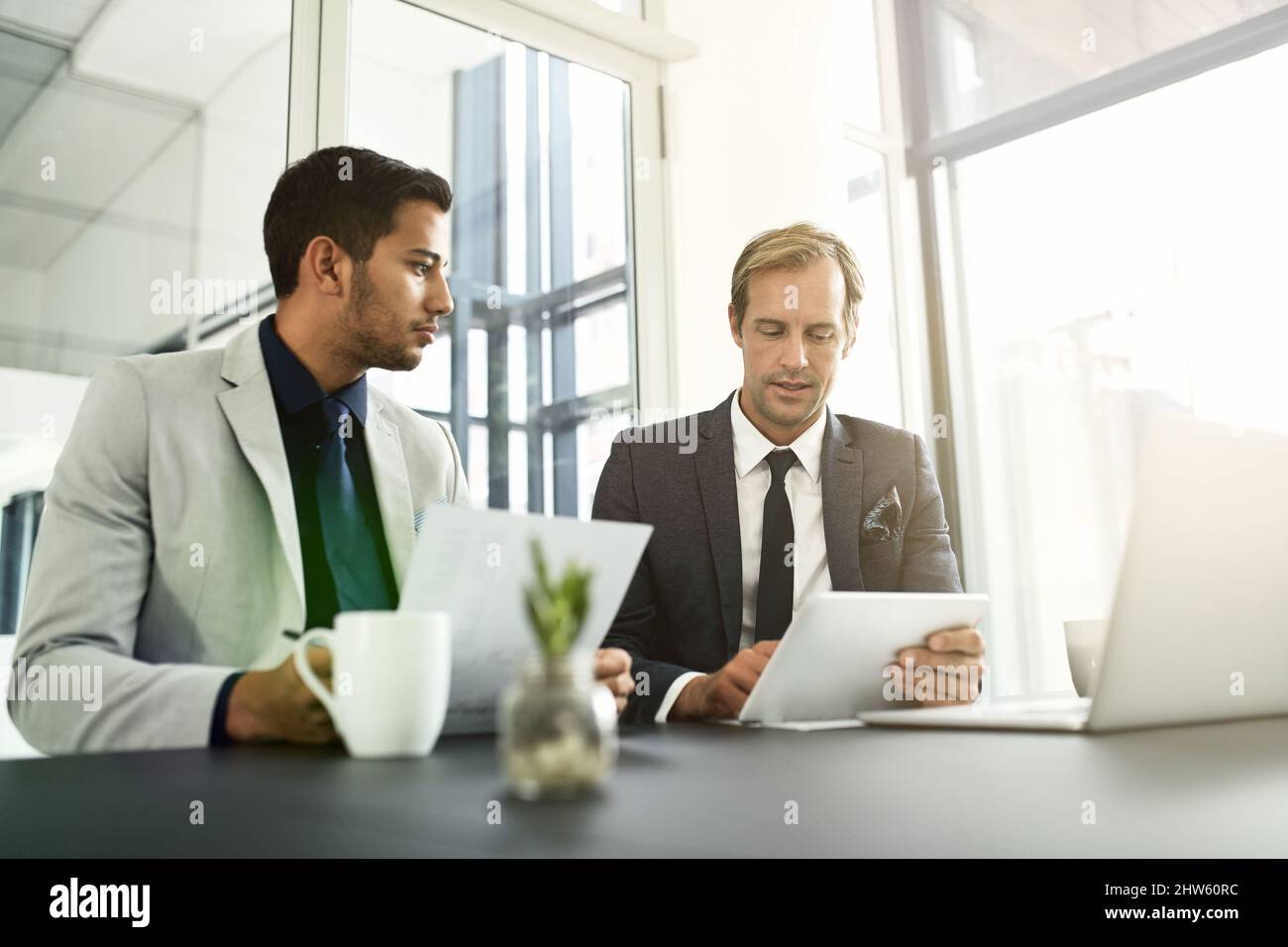 La technologie leur permet de traiter plus d'informations que les méthodes manuelles. Photo de deux hommes d'affaires ayant une discussion dans un bureau. Banque D'Images
