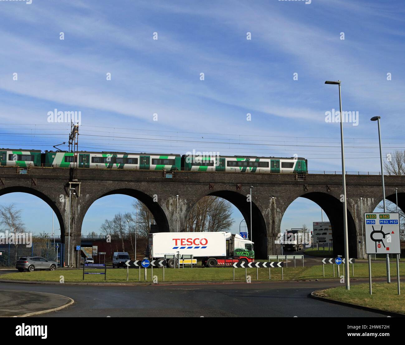 Un train des West Midlands traverse l'énorme Ditton Viaduct en direction de Birmingham, tandis qu'un camion Eddie Stobart passe au-dessous avec une remorque Tesco Banque D'Images