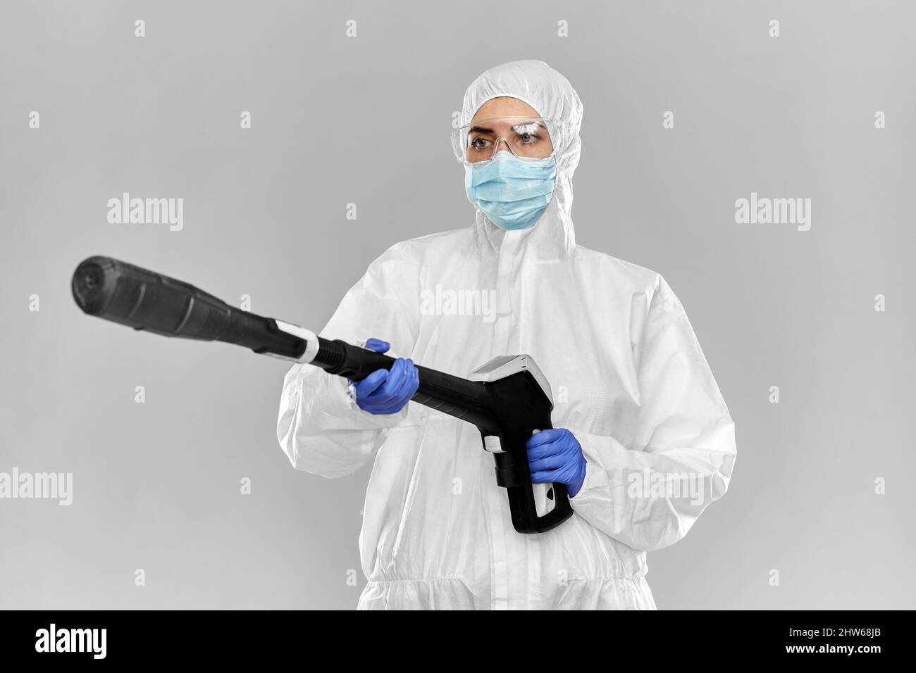 travailleur sanitaire dans des matériaux dangereux avec nettoyeur à pression Banque D'Images