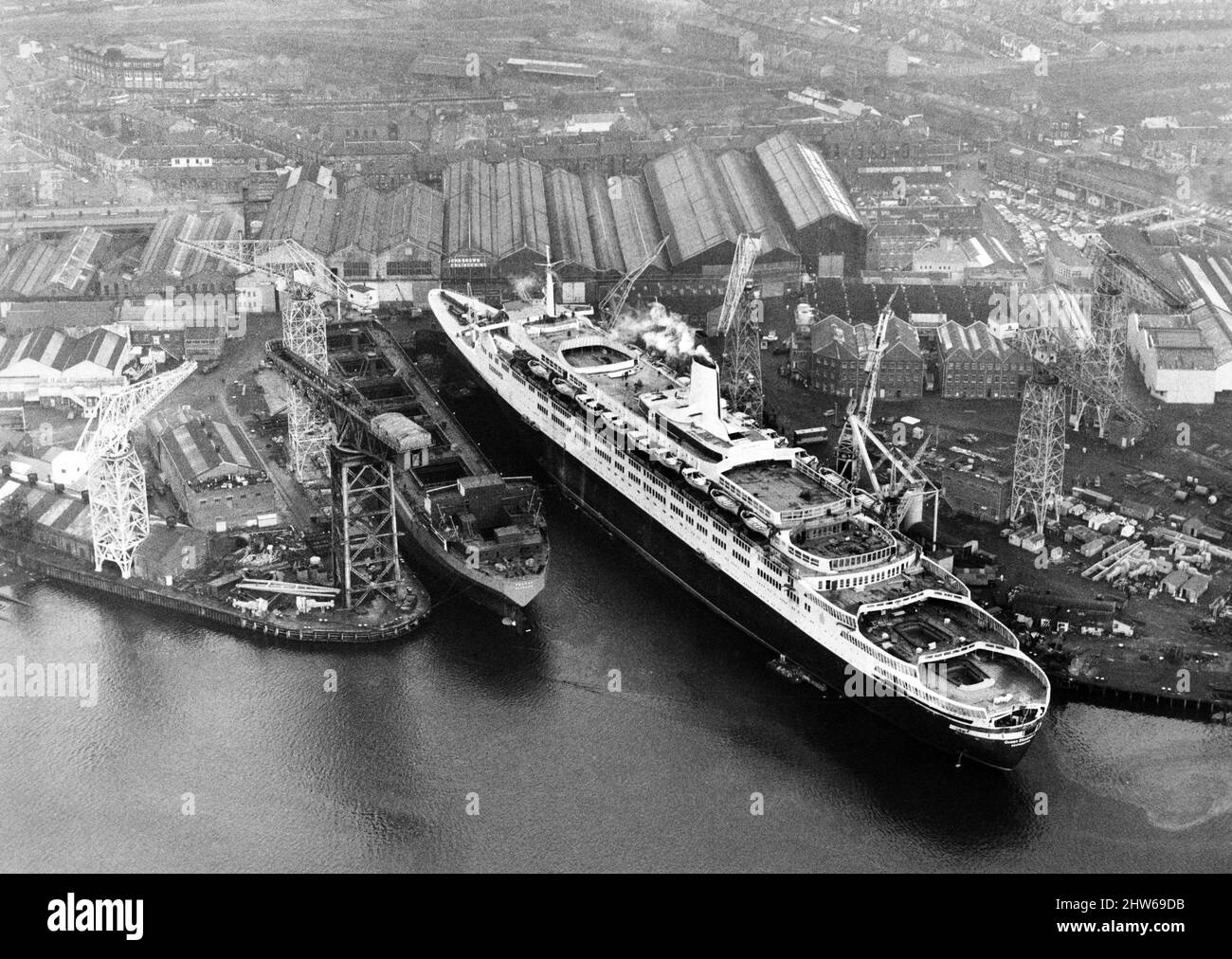 La reine Elizabeth 2, paquebot, construite pour la ligne Cunard qui était exploitée par Cunard comme paquebot transatlantique et navire de croisière de 1969 à 2008. Photo : QE2 en raison de la voile depuis la berge d'aménagement du chantier naval de John Brown sous le commandement du capitaine 'Bil' Warwick, des touches de finition sont réalisées. 14th novembre 1968. Banque D'Images