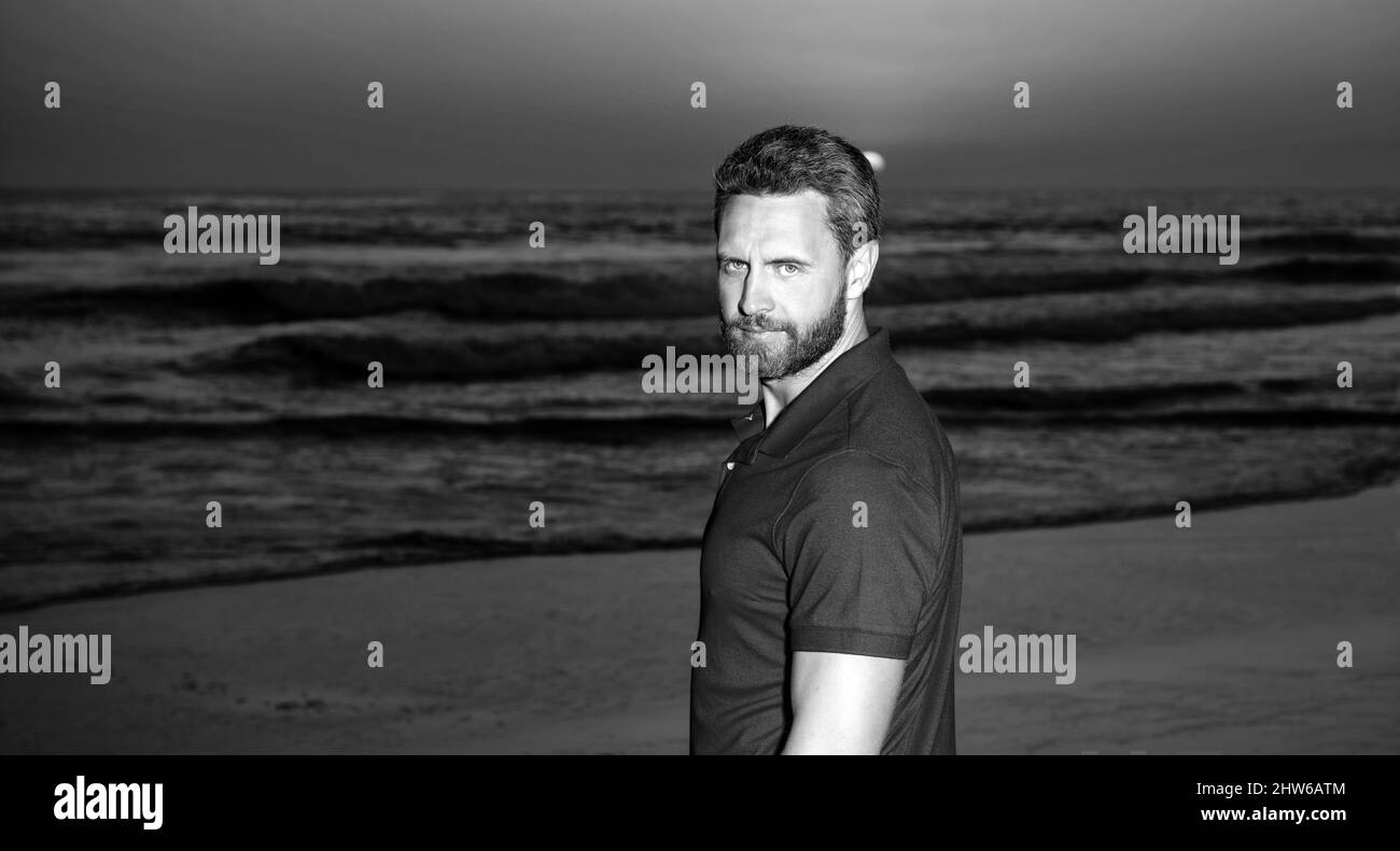 portrait d'homme charismatique sur la mer au coucher du soleil sur la plage d'été, en été Banque D'Images