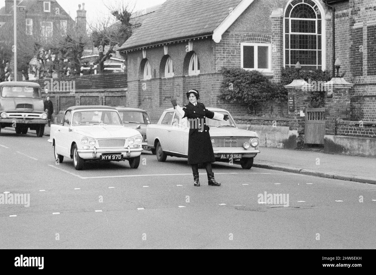 Le premier garde-trafic britannique à contrôler la circulation au lieu de réserver des voitures pour des infractions de stationnement, Mme Joyce Roffey, en service à un carrefour très animé à Croydon, Surrey, à la jonction de Park Lane et de Coombe Road, le 2nd janvier 1967. Banque D'Images