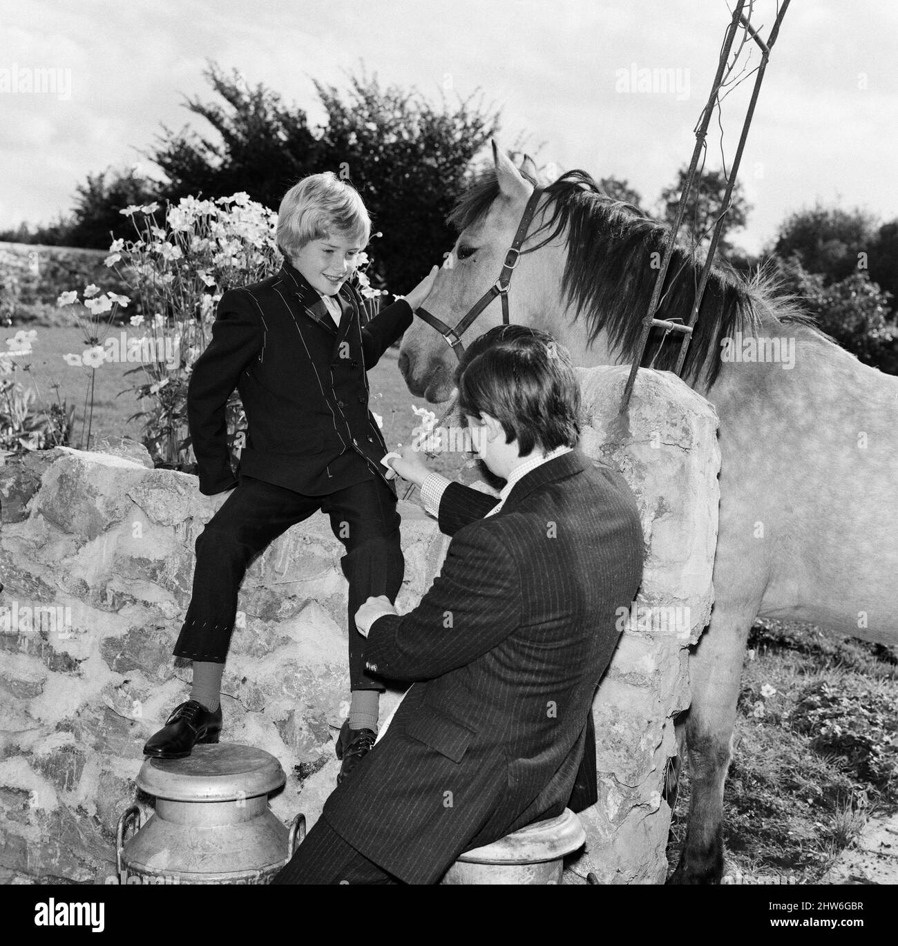 La star du film pour enfants Mark Lester, âgée de 10 ans, est adaptée à la combinaison qu'il portera lorsqu'il sera présenté à la princesse Margaret au premier ministre du film de Londres Oliver!. La mise en place par showbiz tailleur Doug Davis est à Singmore Farm près de Newton Abbot, Devon, où Mark a séjourné avec ses parents. Doug Davis trouve qu'il n'est pas facile de garder Mark à un endroit assez long pour faire la tenue, car Mark trouve le cheval taffy plus intéressant. 23rd septembre 1968. Banque D'Images