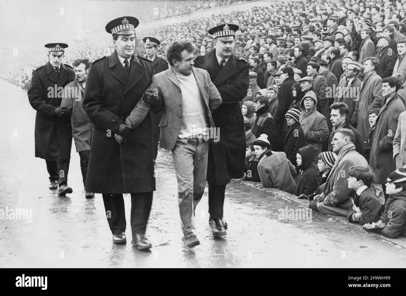 Newcastle United contre Celtic 17 février 1968 - deux fans celtiques sont escortés du parc St James par la police lorsque les Glasgow Rangers se sont affrontés Unis lors de la demi-finale de la coupe Fairs de 1969 Mashem régnaient sur Tyneside. La même chose s'est produite lors d'une rencontre amicale supposée à St James'Park en 1968 avec l'autre moitié de la vieille société de Glasgow, Celtic. La police escorte deux Glasswegians - alimentés par la boisson et pire pour l'usure - hors du stade. Banque D'Images