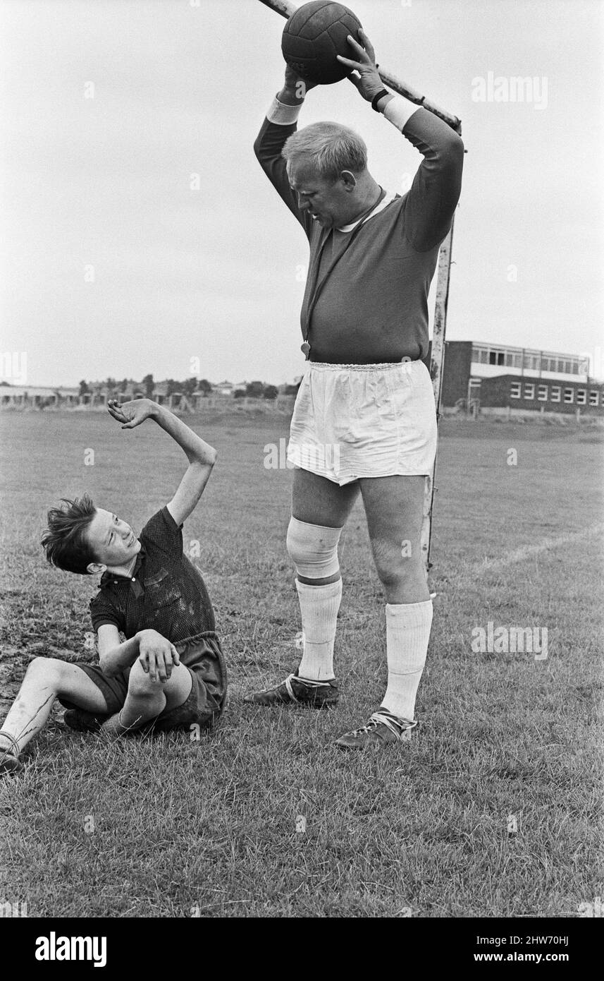 David Bradley, (14 ans) jouant la partie de Billy Casper, en photo avec son Kestral, sur le tournage du film Kes. Ici Billy Casper joue le gardien de but dans la scène de football de l'école. Avec lui, M. Sugden, joué par Brian Glover. M. Sugden pense qu'il est Bobby Charlton, portant un maillot Manchester United et commandant ses joueurs sur le terrain. KES est un film dramatique de 1969 réalisé par Ken Loach et produit par Tony Garnet. Le film est basé sur le roman de 1968 A Kestrel for a Knave, écrit par l'auteur de Barnsley Barry Hines. Le film est classé septième dans le Brit Banque D'Images