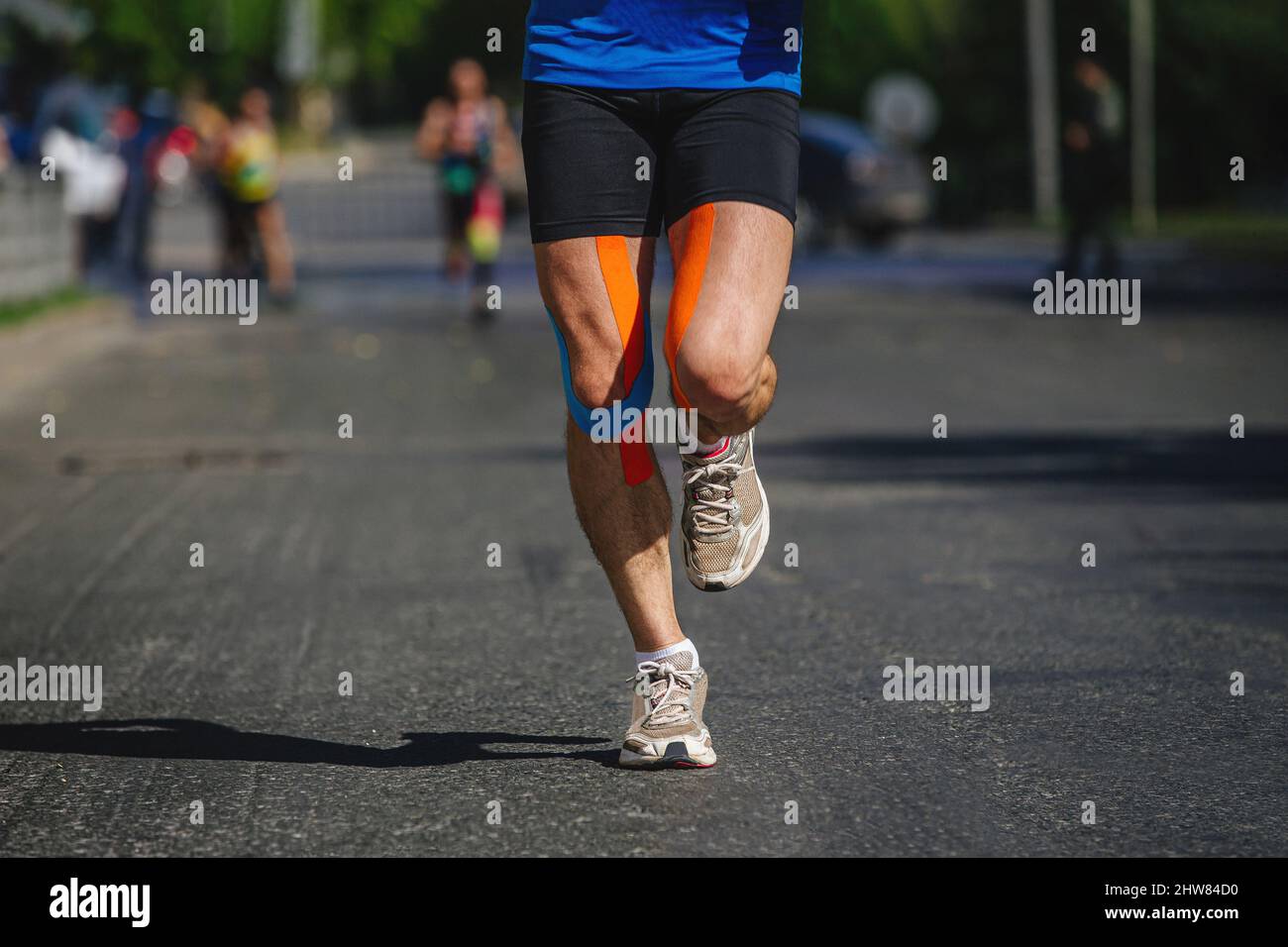 jambes coureur homme avec kinésio bande course marathon Banque D'Images