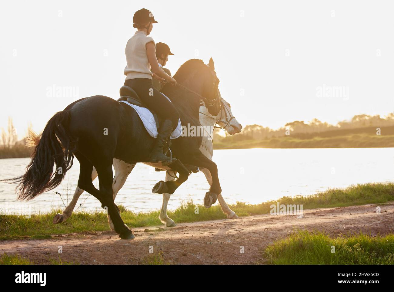 Personne ne peut enseigner l'équitation aussi bien qu'un cheval. Photo de deux femmes méconnues qui ont pris leurs chevaux à l'extérieur sur un terrain. Banque D'Images