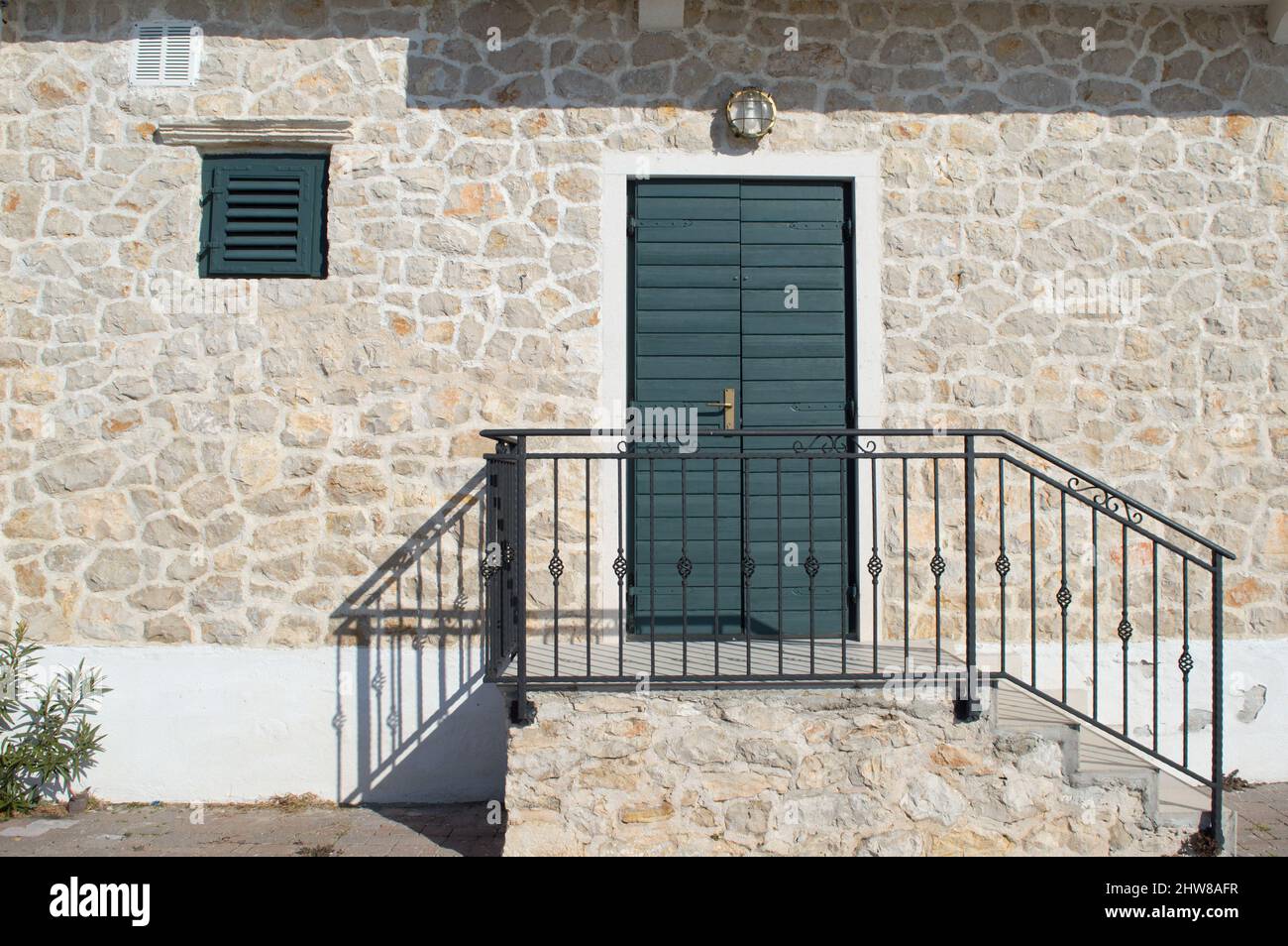 Porte verte authentique sur une maison en pierre caractéristique de la zone côtière en Méditerranée Banque D'Images