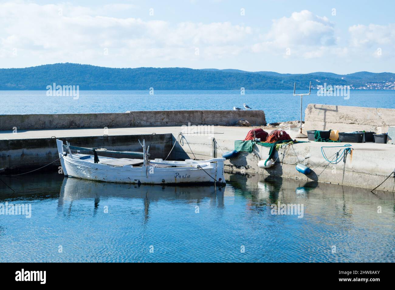 Bateau de pêche traditionnel en bois amarré sur l'ancienne jetée avec filets de pêche préparés, à Bibinje, Croatie Banque D'Images
