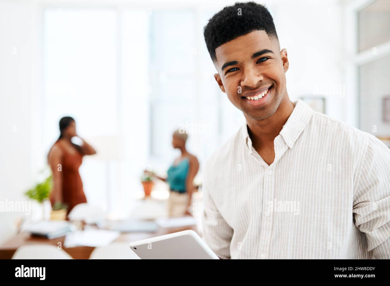 La technologie est aussi innovante que ses conceptions. Portrait d'un jeune homme d'affaires utilisant une tablette numérique dans un bureau moderne. Banque D'Images