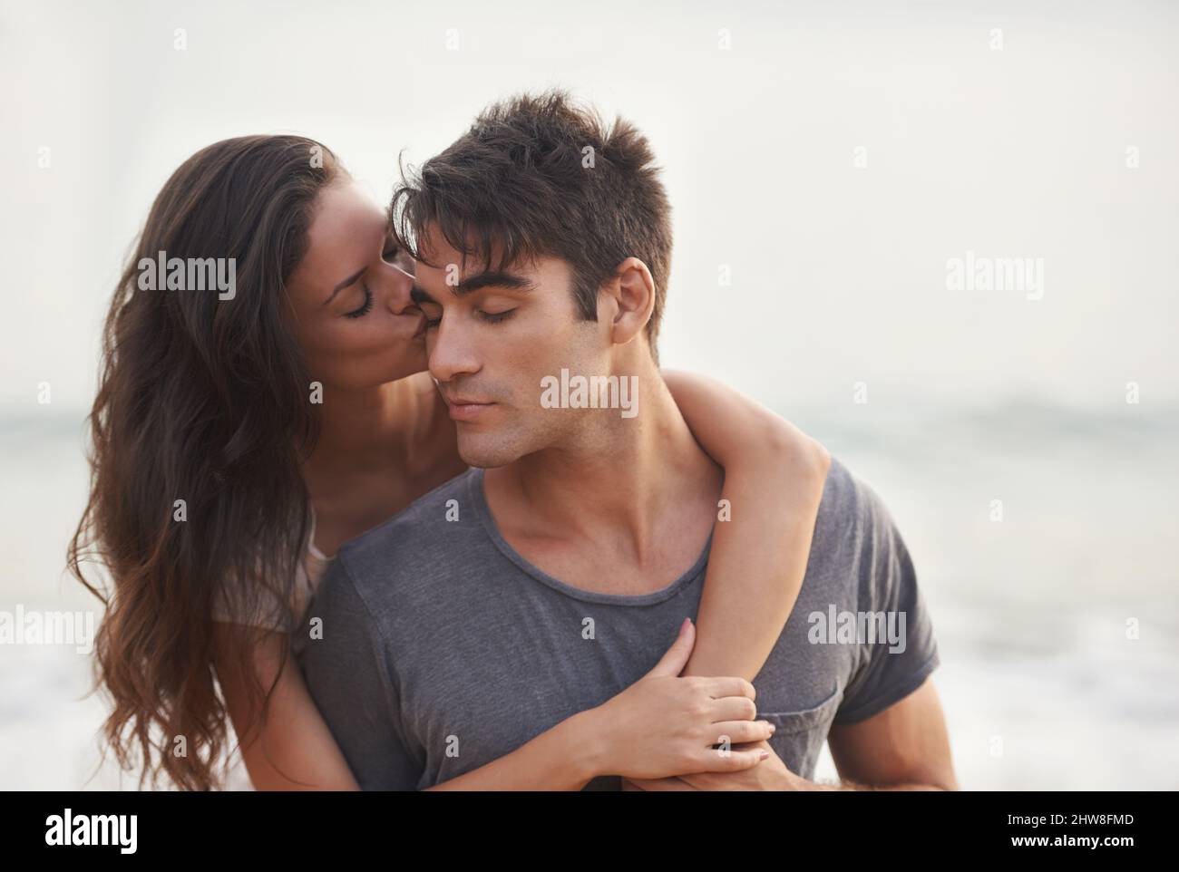 La chance dans l'amour. Photo courte d'un jeune couple affectueux à la plage. Banque D'Images