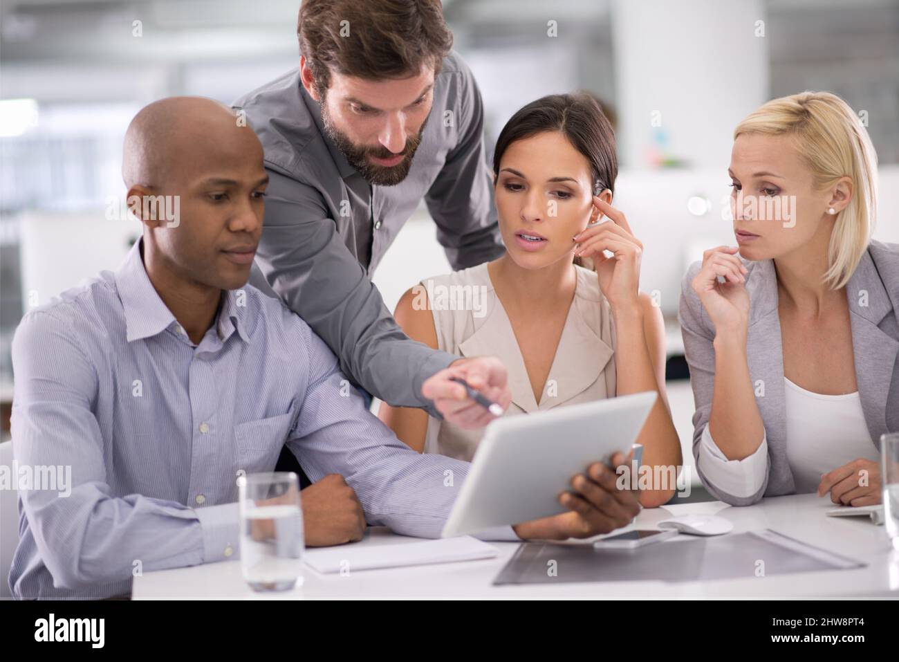 C'est là que nous pouvons économiser de l'argent. Photo d'un groupe de professionnels discutant du contenu d'une tablette pendant une réunion. Banque D'Images