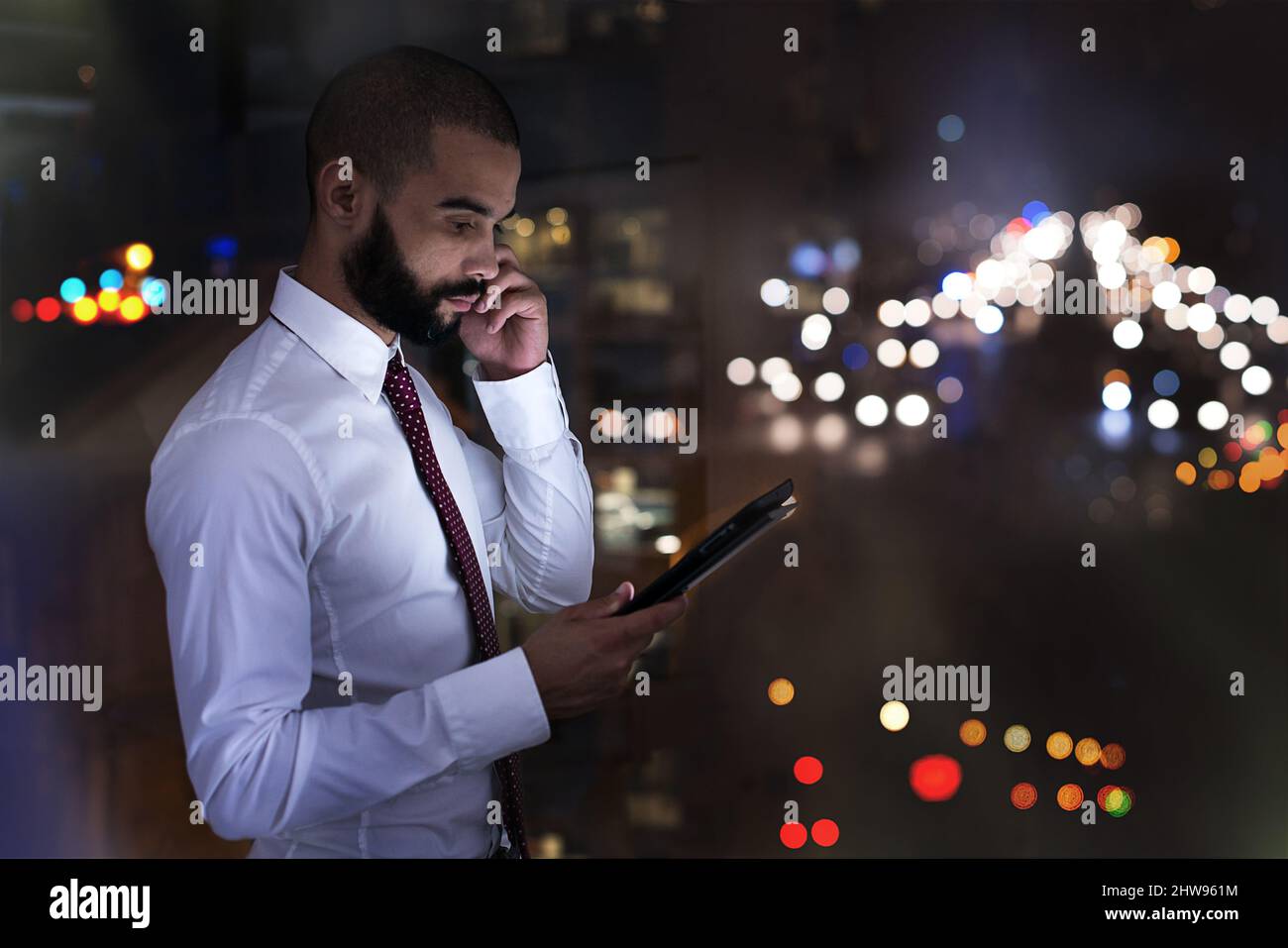 Photo d'un homme d'affaires parlant sur son téléphone portable tard dans la nuit. Des hommes d'affaires réels ont tourné sur place. Puisque ces emplacements sont la vraie chose, et Banque D'Images