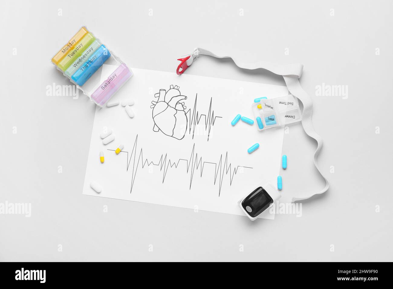 Composition avec cardiogramme, oxymètre de pouls et pilules sur fond blanc Banque D'Images