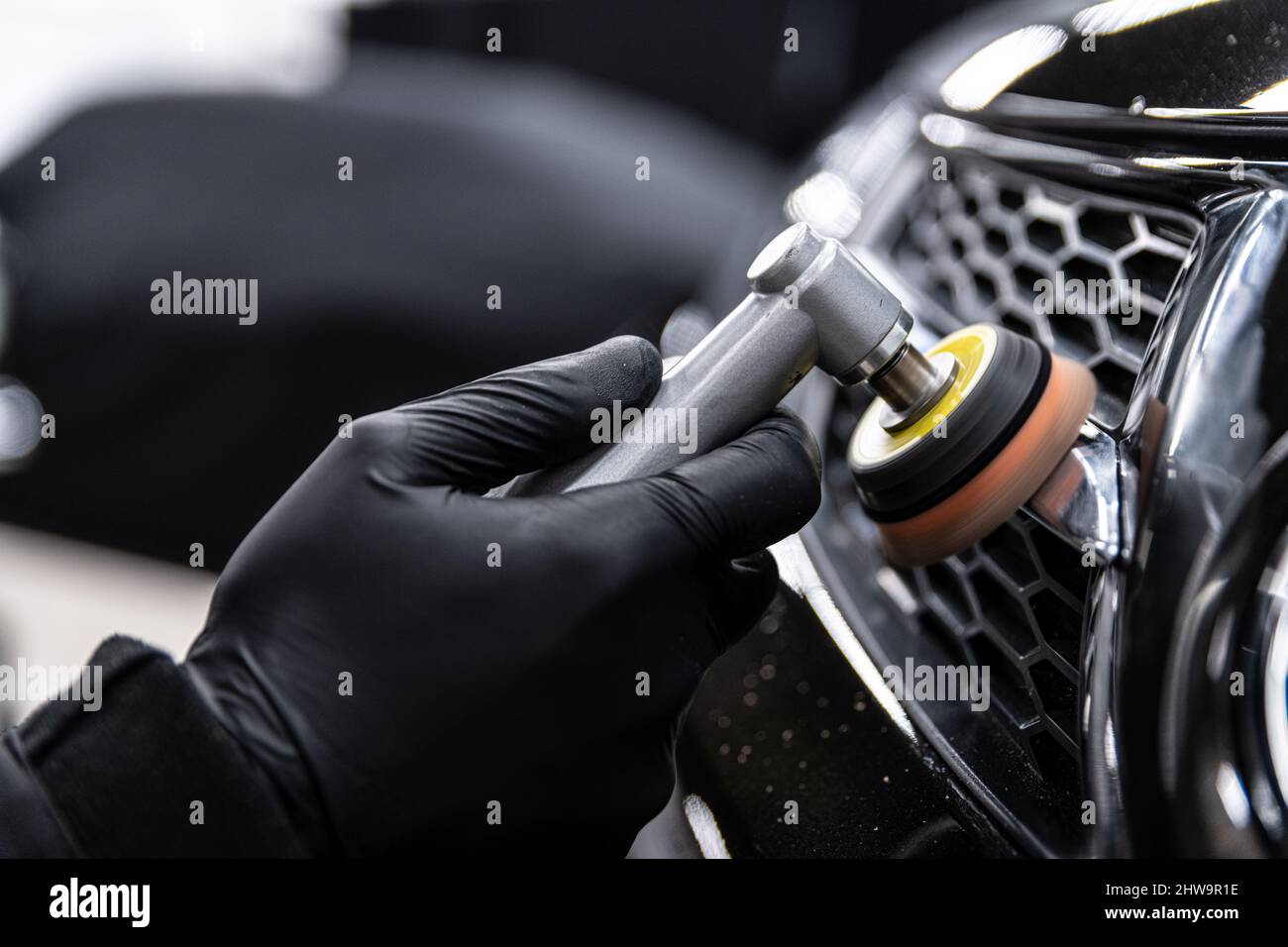 Un technicien en habillage de voiture pour polir le décor de chrome brillant sur la voiture Banque D'Images