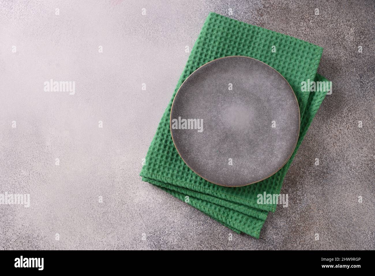 Table St Patrick avec assiette grise et serviette verte sur fond gris pour votre menu ou votre recette. Vue de dessus. Copier l'espace. Banque D'Images