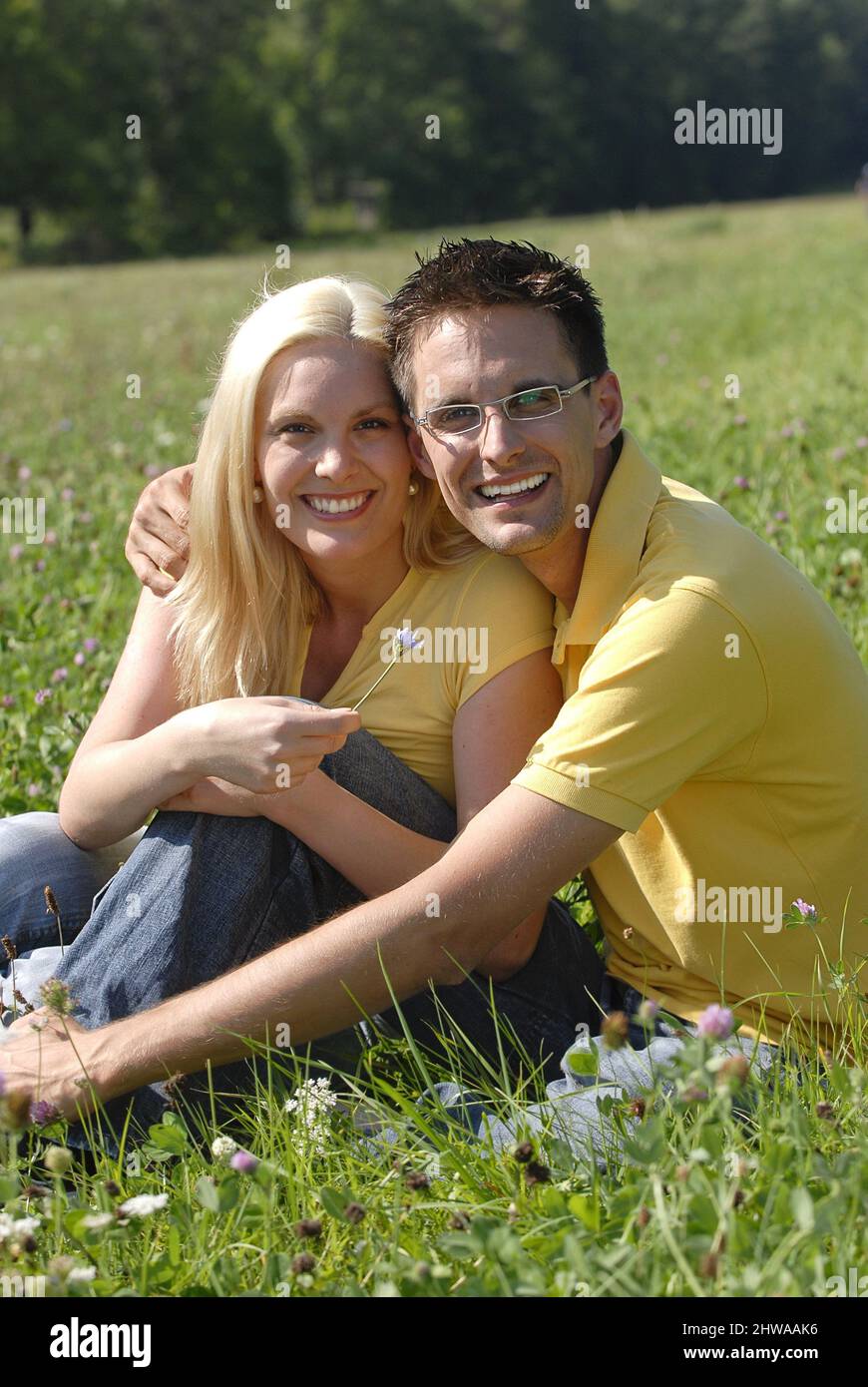 Couple amoureux assis dans un pré en été, Allemagne Banque D'Images
