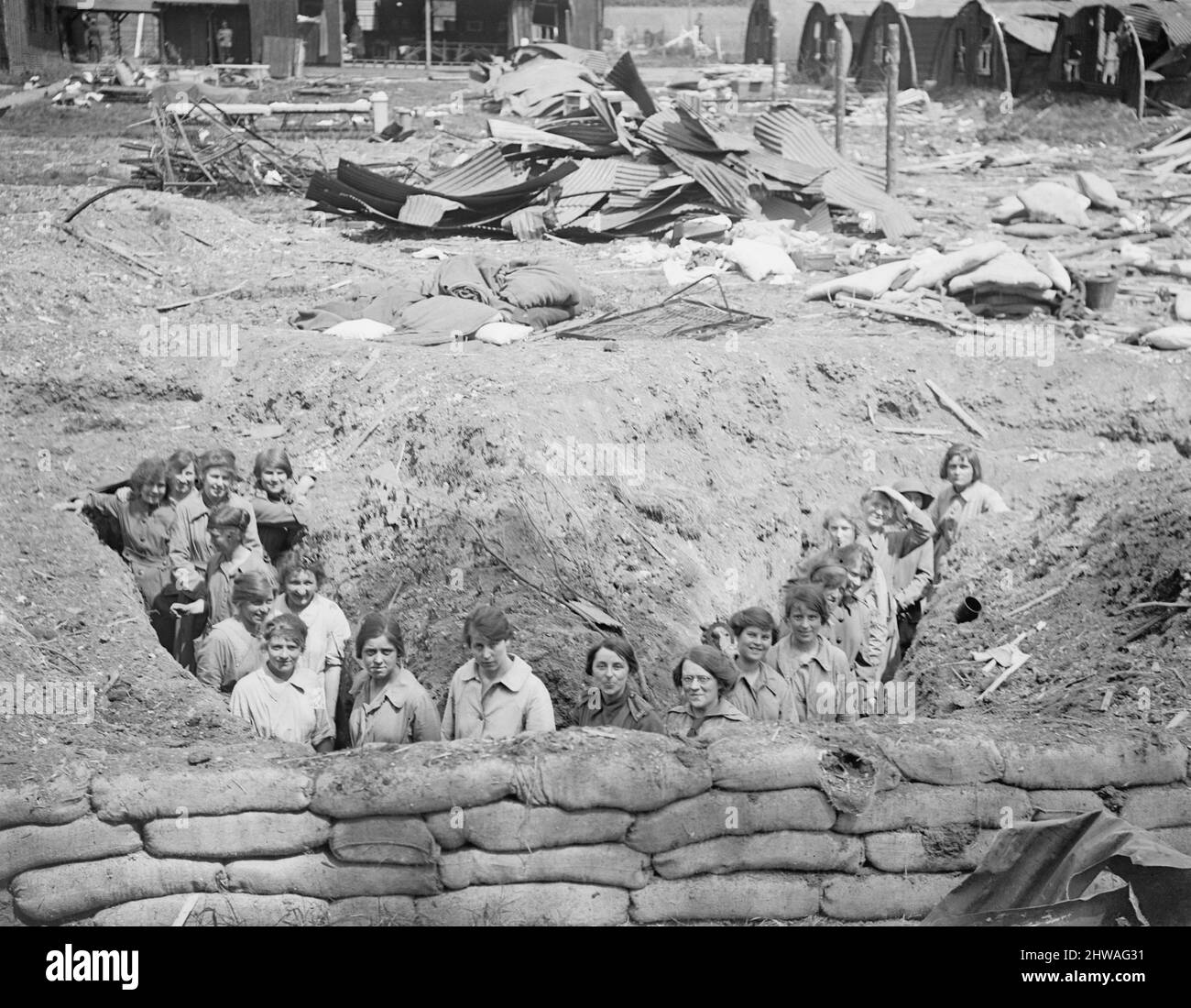 Membres du corps auxiliaire de l'Armée féminine (CAAC) dans une tranchée construite pour abriter en cas d'attaque aérienne à Abbeville, le 22 mai 1918. En arrière-plan se trouvent des débris de cabanes de Nissen détruits dans un raid aérien. Banque D'Images