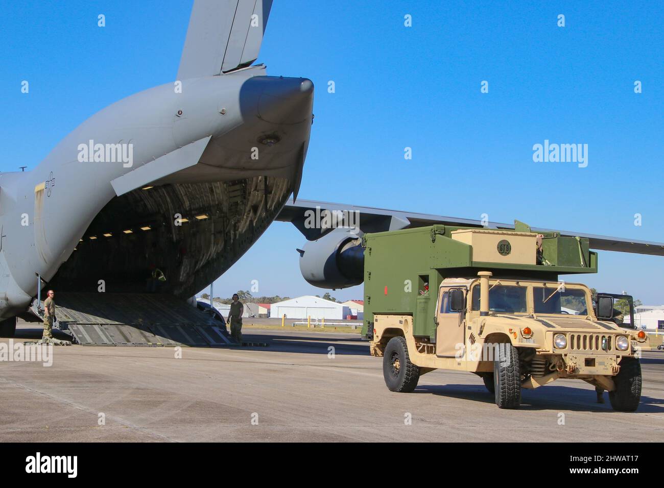 Les membres du service de l'armée américaine affectés à la division d'infanterie 3rd se préparent à charger un Humvee dans un C-17 Globemaster III de la Force aérienne pour le déploiement dans la zone d'opérations de l'armée américaine en Europe et en Afrique à partir de l'aérodrome de l'armée de Hunter, en Géorgie, le 2 mars 2022. L'équipe de combat de la Brigade blindée de 1st basée à fort Stewart, 3rd ID, se rendera en Allemagne pour rassurer les alliés de l'OTAN, dissuader l'agression russe et être prête à soutenir toute une série d'autres exigences dans la région. (É.-U. Photo de l'armée par le capitaine John Howard) Banque D'Images