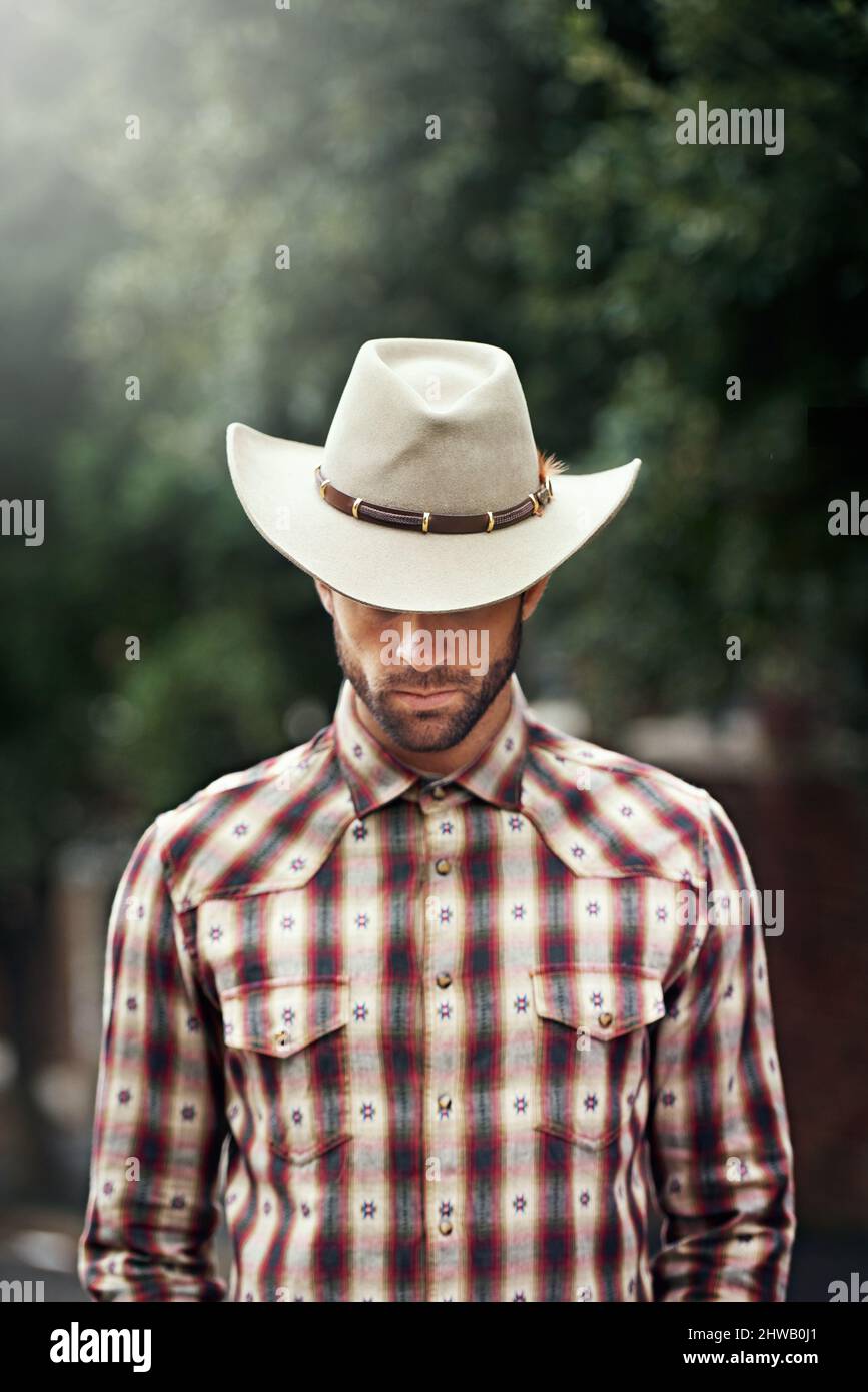 Les rois ont des couronnes, mais un cow-boy n'a qu'un chapeau. Photo d'un beau cow-boy portant une chemise à carreaux et stetson. Banque D'Images