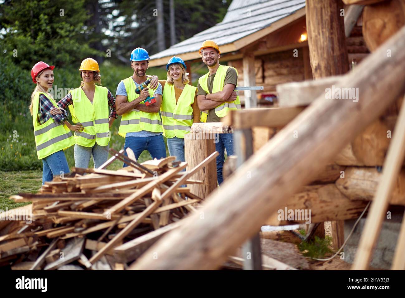 Groupe de travailleurs de la construction équipe puissante. Jeunes travailleurs de la construction ensemble. Bâtiment de ossature en bois. Industrie de la construction, immobilier Banque D'Images