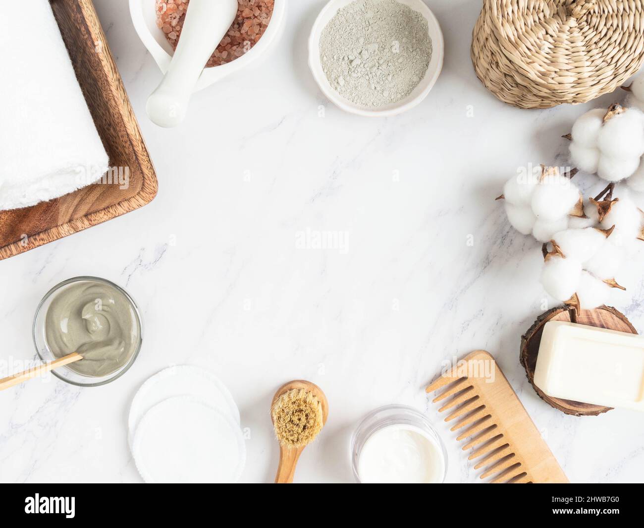 Concept de soins de la peau à domicile. Argile bleue biologique pour masque cosmétique facial, tampon de coton, savon, bougie, crème, serviette de coton et sel de mer dans le mortier sur bac de marbre Banque D'Images