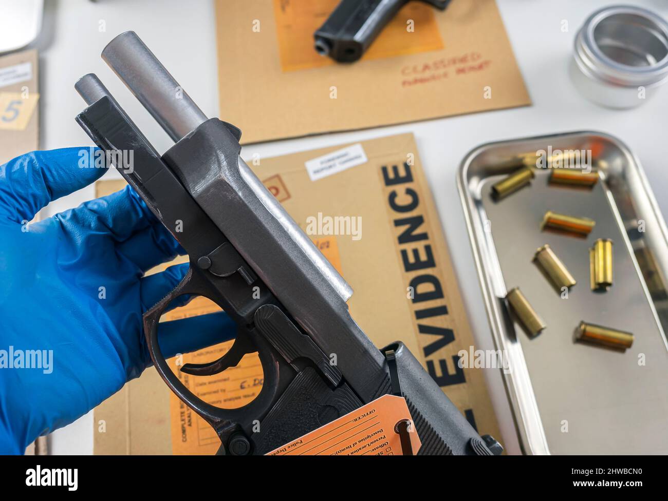 Agent de police scientifique examinant les traces d'un fusil en laboratoire balistique Banque D'Images