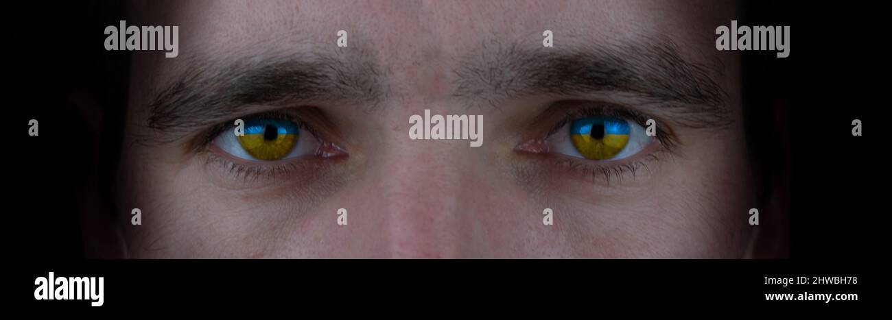 Gros plan du visage masculin avec des yeux jaunes bleus. Symbole du patriotisme du peuple ukrainien. Bannière Banque D'Images